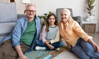 Image de grands parents pendant une visite chez leur petit enfant