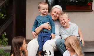 Grands parents et enfants devant maison