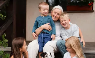 Grands parents et enfants devant maison